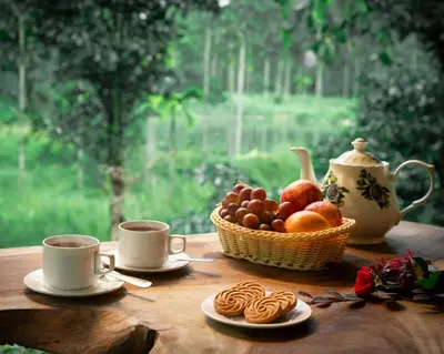 a table with two cups of coffee and a basket of fruit at De Spicewoods, AC Cabin, Pool, Couple only in Kalpetta