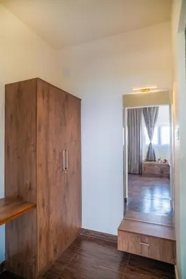 a room with a wooden cabinet and a mirror at The Misty Meadows in Coonoor