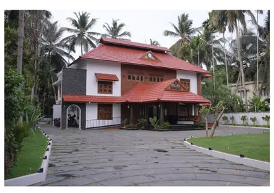 a house with a red roof and a driveway at Dr Indulekhas Ayurvedic Wellness And Rejuvenation in Tellicherry