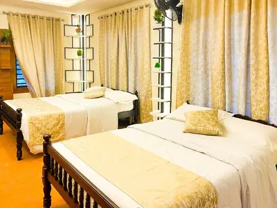 a bedroom with two beds and curtains at JoeVilla Homestay Near Kottiyoor in Kelakam