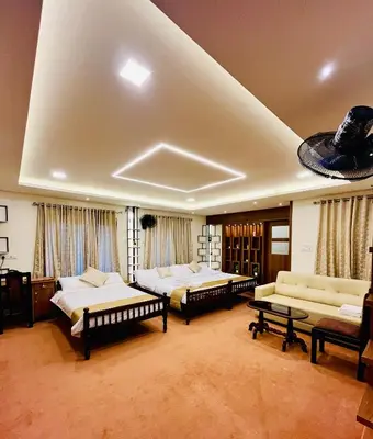 a room with three beds and two couches at JoeVilla Homestay Near Kottiyoor in Kelakam