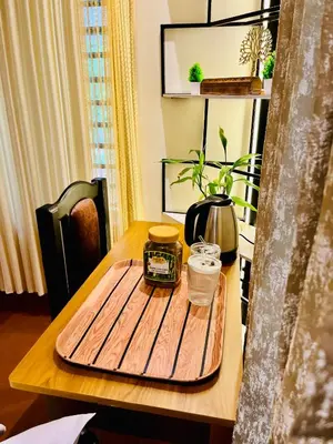 a table with a wooden cutting board on top of it at JoeVilla Homestay Near Kottiyoor in Kelakam