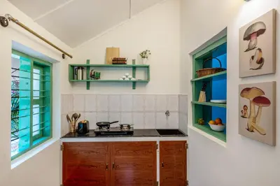 a kitchen with a stove and a counter top at Sliceinn Somewhere Together In Biligeri in Madikeri