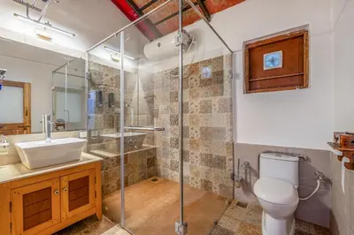 a bathroom with a shower and a toilet and a sink at Sliceinn Somewhere Together In Biligeri in Madikeri