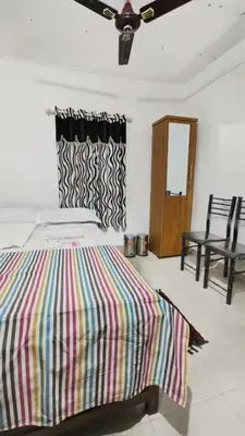 a bedroom with a bed with a colorful striped blanket at Kadingis homestay and eco tourism in Kadalundi