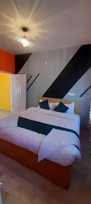 a bedroom with a large bed with white sheets and blue pillows at Retro Radiance in Ooty