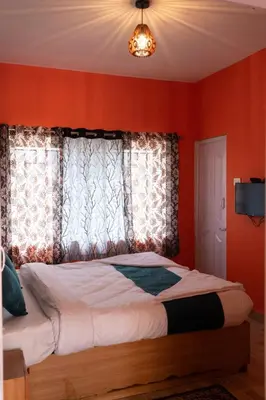 a bedroom with red walls and a bed with a window at Retro Radiance in Ooty