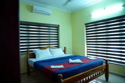 a bedroom with a bed with two towels on it at Sree Nandhavanam Homestay in Guruvāyūr