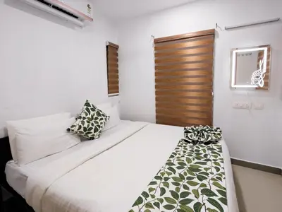 a bedroom with a white bed with a wooden door at Ibex Resorts, Malampuzha - Kava Eco Camp and Caravan Park in Palakkad