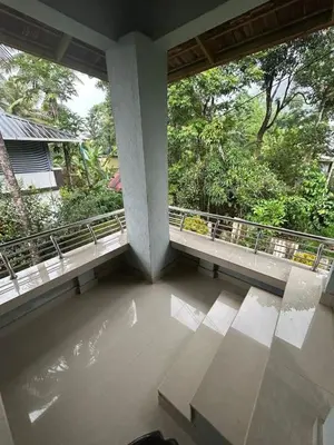 a balcony with two windows and a view of trees at Rifa homestay in Kalpetta