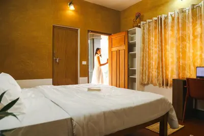 a woman in a white dress looking out of a window at Namastay - Haritha Thara in Kalpetta