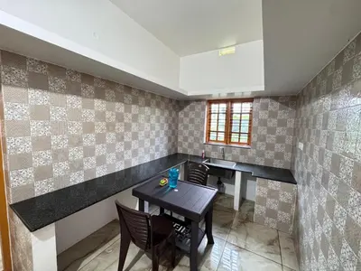 a dining room with a table and chairs at Sukhavana home stay suite in Madikeri