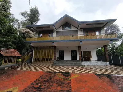a house with a balcony and a patio at Sukhavana home stay suite in Madikeri
