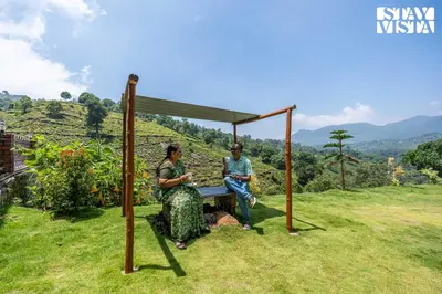 two people sitting on a bench under a canopy at StayVista at Ambrosia access to water stream in Kotagiri