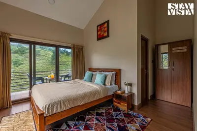 a bedroom with a bed and a large window at StayVista at Ambrosia access to water stream in Kotagiri