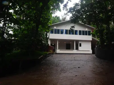 a white house with a lot of windows at Fogland Villa in Vaduvanchal