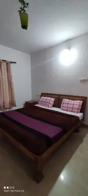 a bedroom with a bed with purple sheets and pink pillows at Sahari Villa, Vattavada in Vattavada