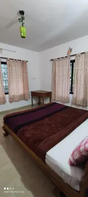 a large bed in a room with windows at Sahari Villa, Vattavada in Vattavada
