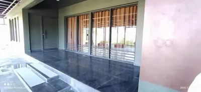 a room with black tile flooring and large windows at Ranches & Kennels 2BR Coorg in Kushālnagar
