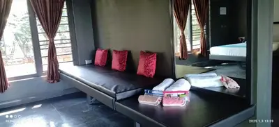 a room with a couch with pillows on it at Hidden Haven 1BR Coorg in Kushālnagar