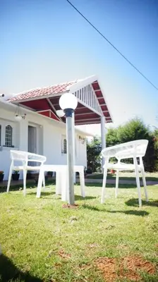 two white benches in front of a house at Hills Dale ooty 3 bhk vintage tea estate villa in Ooty
