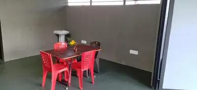 a red dining room table with red chairs in a room at Coorg Countryside 1BR in Kushālnagar