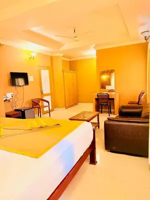 a hotel room with a bed and a living room at K M S Residency in Tirūr