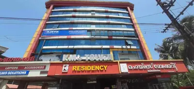 a tall building with signs on the side of it at K M S Residency in Tirūr