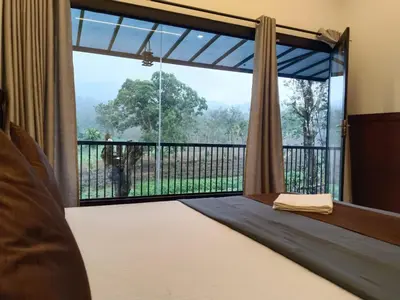 a bedroom with a bed and a large window at The Tree House in Vythiri