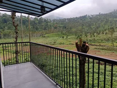 a giraffe standing on a balcony with a view at The Tree House in Vythiri