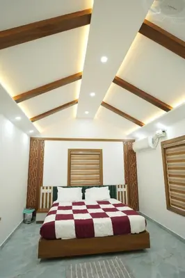 a bedroom with a bed with a red and white blanket at Wayanadanhuts Home Stay in Sultan Bathery