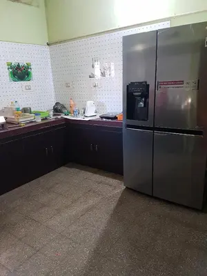 a kitchen with a large stainless steel refrigerator at Anand Bagh in Pollāchi