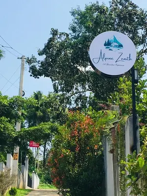 a sign for the entrance to a nunez kazettel at Alpine Zenith - Luxury Wooden Cottages in Meppādi