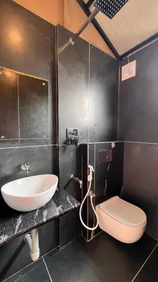 a bathroom with a sink and a toilet at Alpine Zenith - Luxury Wooden Cottages in Meppādi