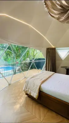 a bed in a room with a large window at Rivergreen resort in Athirappally