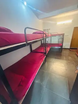 two bunk beds in a room with red sheets at ROYAL HOLIDAY HOMe in Ambalavayal