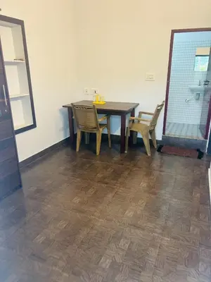 a dining room with a wooden table and chairs at ROYAL HOLIDAY HOMe in Ambalavayal
