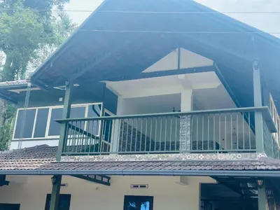 a house with a blue roof with a balcony at ROYAL HOLIDAY HOMe in Ambalavayal