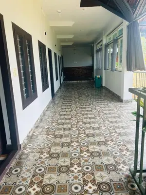 a corridor of a building with a tile floor at ROYAL HOLIDAY HOMe in Ambalavayal