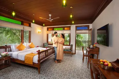 a man and a woman standing in a bedroom at Koviloor Resort in Vattavada