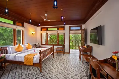 a bedroom with a large bed and a balcony at Koviloor Resort in Vattavada