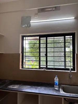 a window in a kitchen with a sink and a bottle of water at AC Arcade in Parli