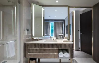 a bathroom with a sink and a large mirror at Merlis Hotel Coimbatore in Coimbatore