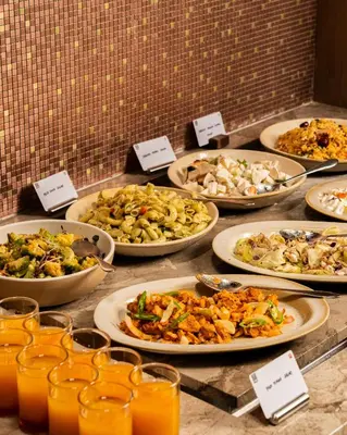 a bunch of plates of food on a table at Merlis Hotel Coimbatore in Coimbatore