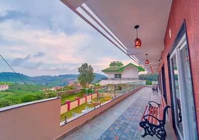 a balcony with a bench and a view of the valley at Ooty Blossom Retreat by VOYE HOMES in Ooty