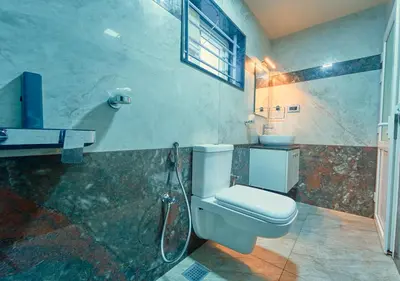 a bathroom with a toilet and a sink at Ooty Blossom Retreat by VOYE HOMES in Ooty
