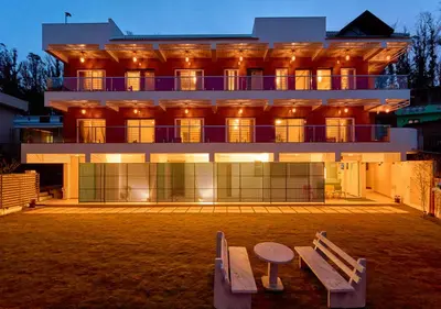 a building with two benches in front of it at Ooty Blossom Retreat by VOYE HOMES in Ooty