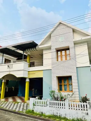 a white house with yellow columns at 3BHK Spacious Villa near Rajagiri Hospital in Ernakulam