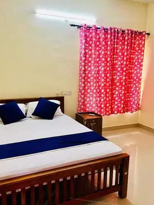 a bedroom with a bed and a red curtain at 3BHK Spacious Villa near Rajagiri Hospital in Ernakulam