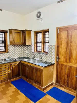 a kitchen with a sink and a wooden door at 3BHK Spacious Villa near Rajagiri Hospital in Ernakulam